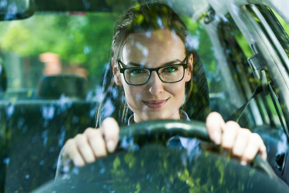 Young attractive woman in glasses driving a car-1