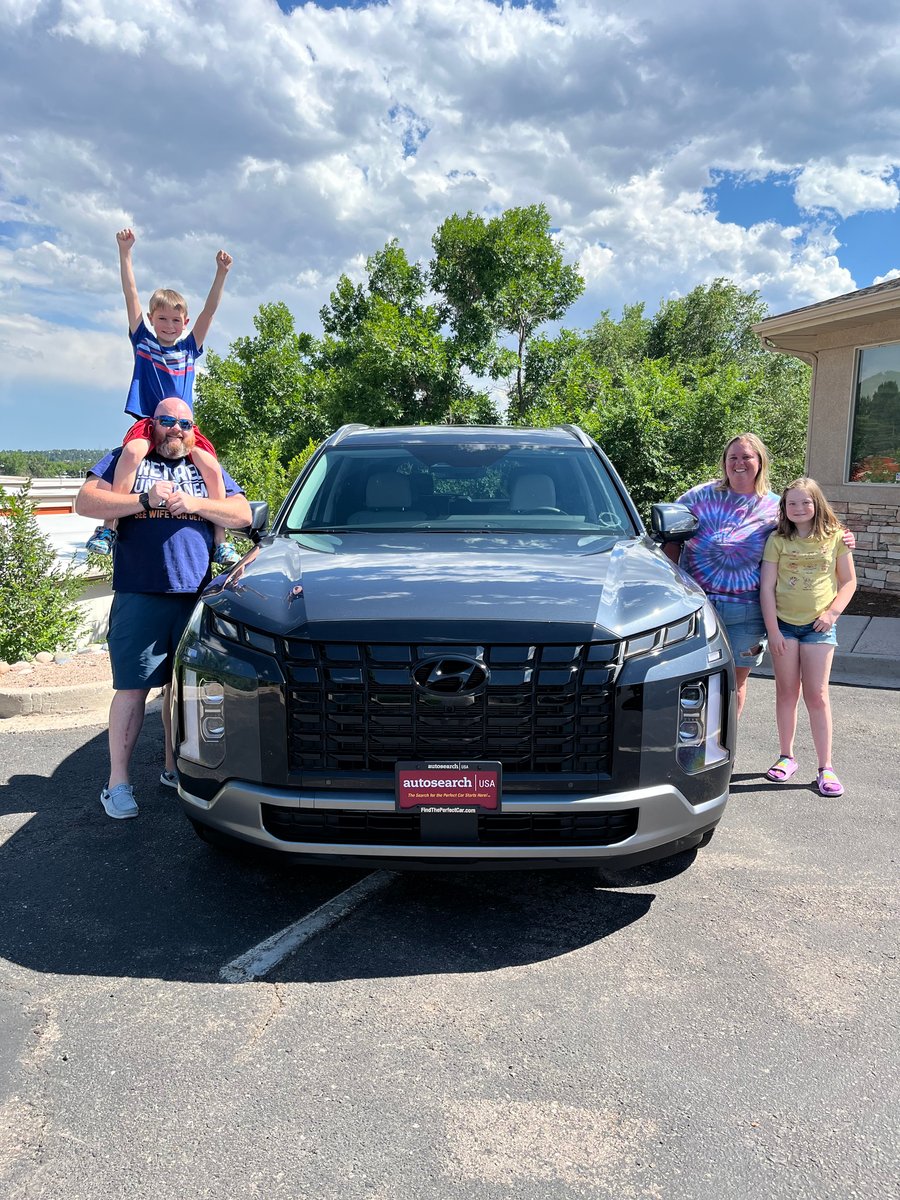 A family with the SUV they bought through RH Auto Brokers